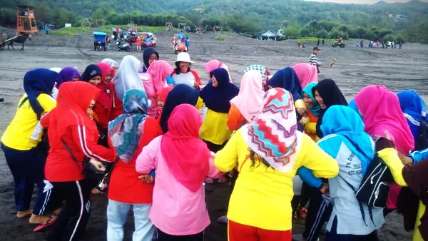 Aktivitas outbound kelompok yang ceria dengan latar belakang ombak pantai selatan Yogyakarta