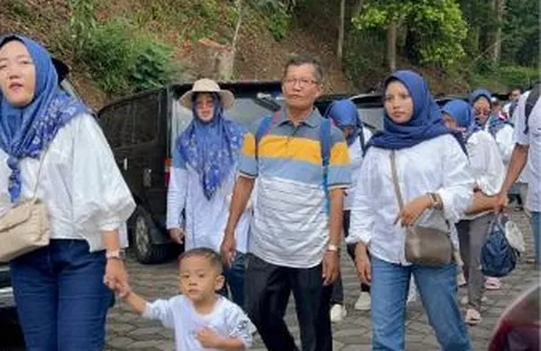 Siswa dan orang tua menikmati wahana klasik seperti sky bike di atas taman bunga Selecta