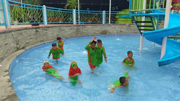 Rekreasi air di kolam renang Parimas Waterpark yang luas dengan latar pegunungan