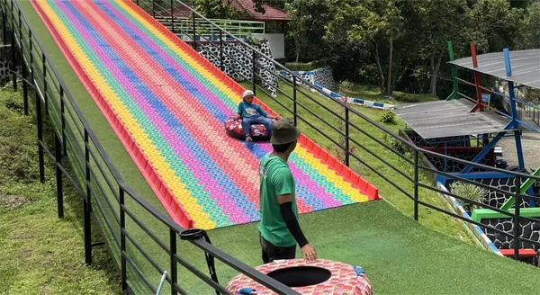 Keceriaan rombongan sekolah saat mencoba wahana rainbow slide di Bhakti Alam