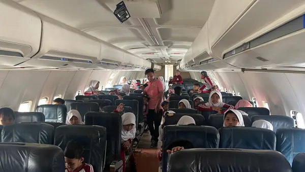 Siswa melihat langsung bagian-bagian mesin pesawat di dalam hanggar