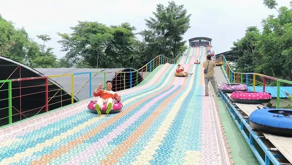Keseruan siswa bermain di wahana perosotan pelangi atau rainbow slide Sebani