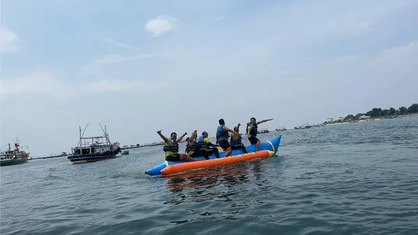 Siswa menikmati suasana pantai pasir putih dan laut biru yang menenangkan